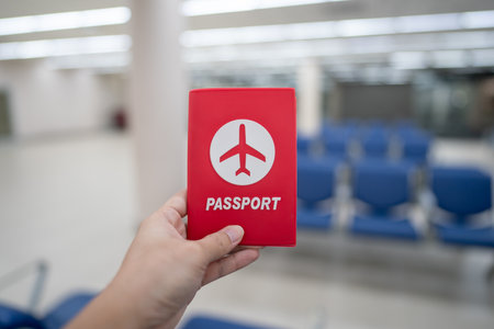 Hand holding passport at the airport at boarding gate.の写真素材