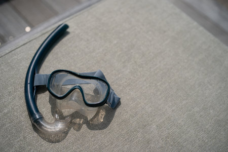 Snorkel and swimming mask lie on a gray pad background.の写真素材
