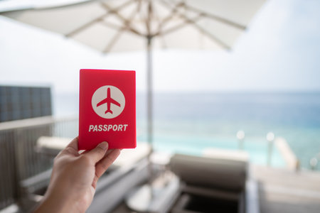 Hand holding passport with sea view background.の写真素材