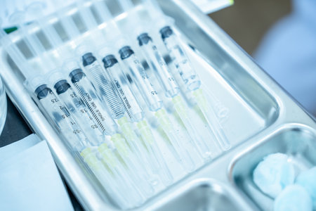 A medical syringe on stainless tray. Drug preparation for patient before treatment.