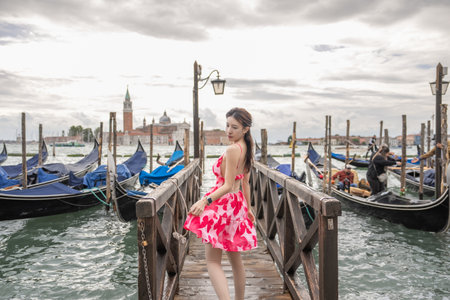 Woman with view of  Gondolas, canals and old town background Italy, Venice.の写真素材