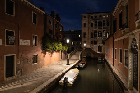 Night view on canal with boat and motorboat, Venice Italy.の写真素材