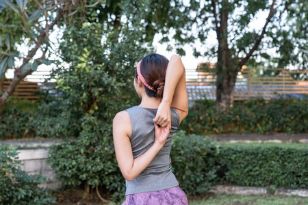Woman stretching in a park during morning exercise routine.の写真素材