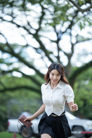 Student girl in Thai university uniform walk in the park outdoor.の写真素材