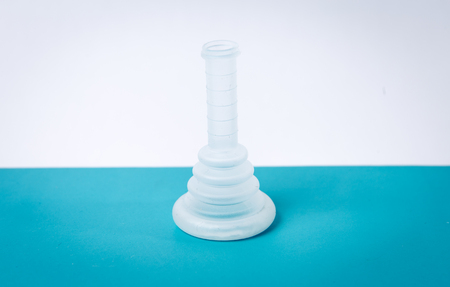external condom catheter conveen used in patient care standing on blue table with white backgroundの写真素材