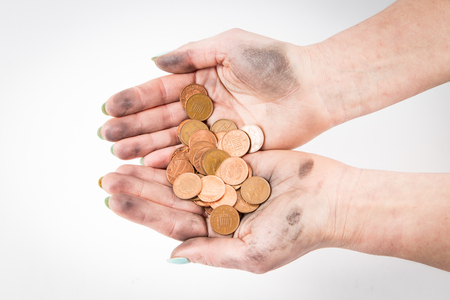 where is muck there is money, two dirty hands holding coins isolated at he white backgroundの写真素材