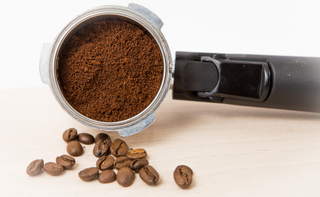coffee portifilter side way with coffee been and powder at the white background isolatedの写真素材
