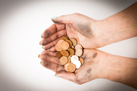 where is muck there is money , two dirty hands holding coins isolated at the white backgroundの写真素材