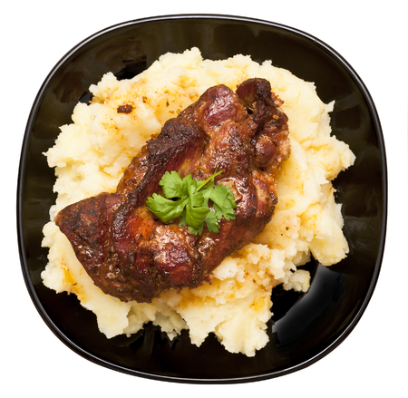 Roasted pork neck with potatoes decorated with coriander leaf isolated on white backgroundの写真素材