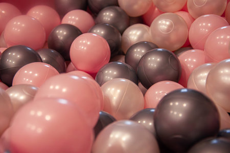 Closeup photo of a pile of plastic balls. Pink, grey, blackの写真素材