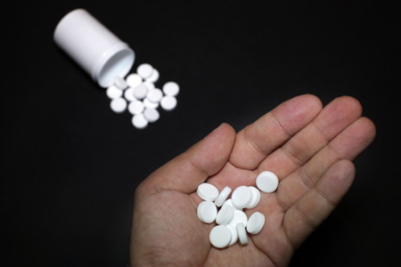 White pills, medicines painkiller. Medications on a black background.の写真素材