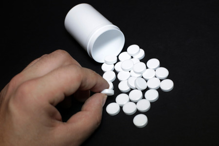 White pills, medicines painkiller. Medications on a black background.の写真素材