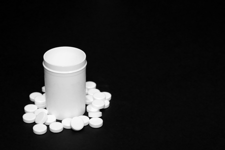 White pills, medicines painkiller. Medications on a black background.の写真素材