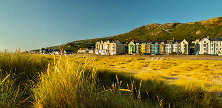 A colourful row of Victorian terraced houses overlooking the sea and beach.の写真素材