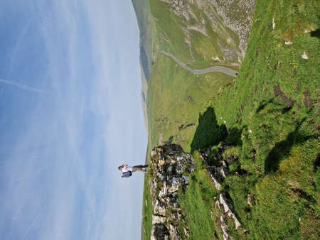Man taking a photo on an edge of England's Peak District National Park, Winnast Pass 2022.