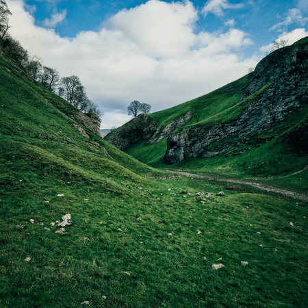 This trio of images captures the raw, untouched splendor of Cave Dale in the Peak District. Each frame invites the viewer on a journey through this ancient limestone valley, where nature's artistry is displayed in verdant hillsides, meandering streams, and striking rock formations. The interplay of light and shadow, coupled with the vivid greens and earthy tones, encapsulates the tranquil yet wild essence of the English countryside. Perfect for editorial use, these images convey a sense of peace, resilience, and natural beauty that are characteristic of Castleton's famous landscapes.の写真素材