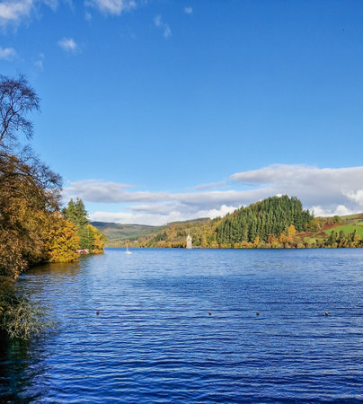 This collection of images captures the enchanting beauty of Lake Vyrnwy in Wales, a testament to both natural beauty and human ingenuity. From the majestic overflow of the dam spilling into lush woodlands to the tranquil roads meandering through autumn-kissed forests, each shot tells a story of serenity and pastoral grace. The presence of a rainbow arcing over the water adds a touch of magic to the scene. These images are imbued with the quiet dignity of the Welsh landscape, ideal for environmental themes, travel and tourism publications, or any narrative celebrating the serene beauty of the United Kingdom's countryside.の写真素材