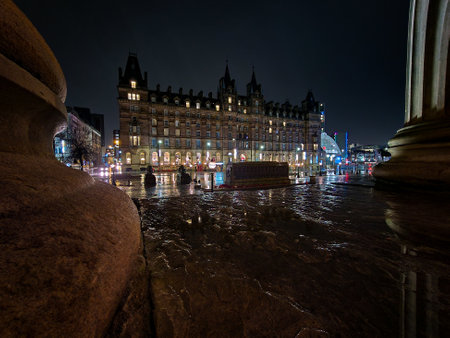 A captivating night view in Liverpool, featuring a glowing billboard and the city's dynamic street life, with reflections on wet surfaces creating a festive atmosphere.のeditorial素材