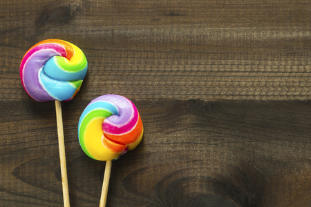 rainbow color lollipops on wooden backgroundの写真素材