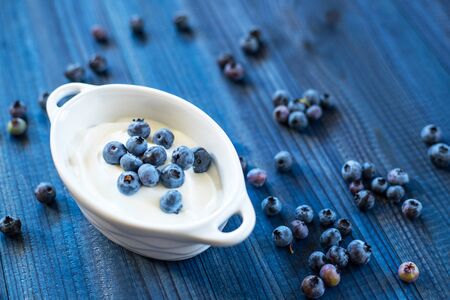 Fresh tasty blueberry with natural yoghurt on woodenの写真素材