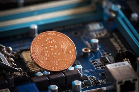 coin with bitcoin logo on computer parts. bussines of cryptocurrency backgroundの写真素材