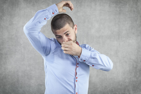 Businessman smelling his armpits の写真素材