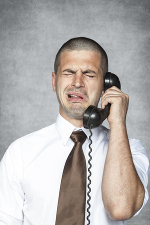businessman crying while talking on the phoneの写真素材