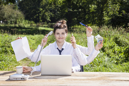 multitasking business woman sitting in the officeの写真素材