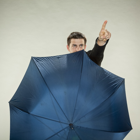 businessman is hiding behind umbrellaの写真素材