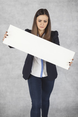 Sad business woman holding a blackboard with space for adの写真素材
