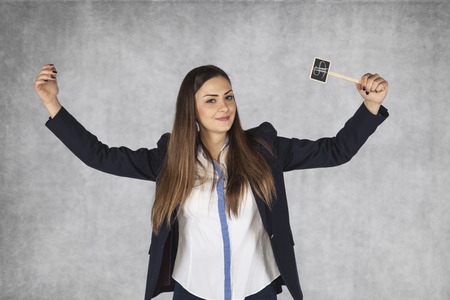 business woman with dollar signs raises her hands in a gesture of successの写真素材
