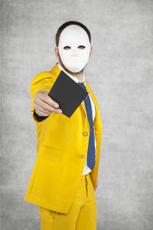 businessman in a suit giving a golden envelope as a giftの写真素材