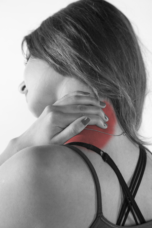 A young woman is struggling with pain, isolated on backgroundの写真素材
