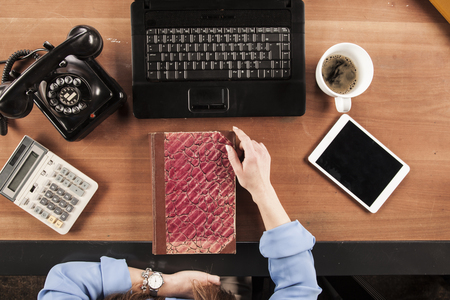 top view, business woman holding a book on the deskの写真素材