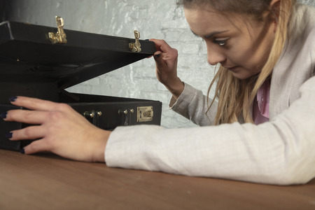Business woman looks into the briefcaseの写真素材