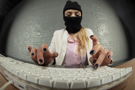 an incognito person steals information from a computerの写真素材