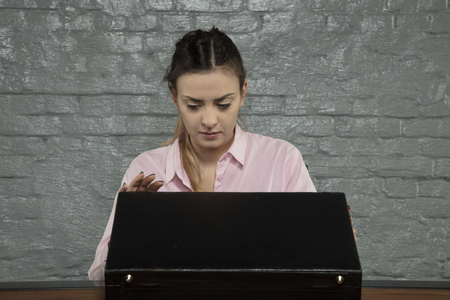 Businesswoman opens her briefcase on the deskの写真素材