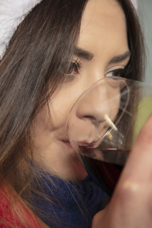 woman is drinking wine while waiting for the holidays, close upの写真素材