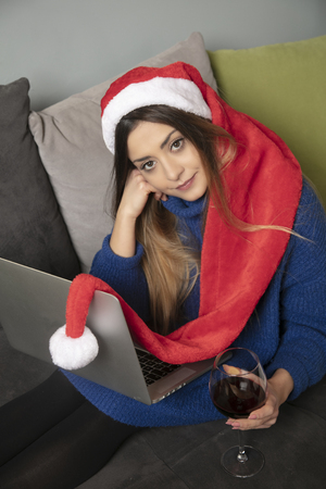 lonely girl in a Christmas cap is drinking wine, top viewの写真素材