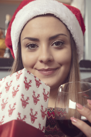 portrait of a beautiful girl with wine in hand and gift, close upの写真素材