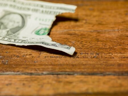 burnt one dollar bill on brown background