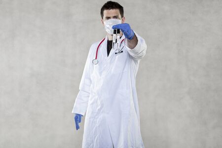 the doctor is holding ampoules for coronavirus testsの写真素材
