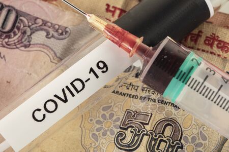 concept of crisis in India caused by virus, test and vaccine on banknoteの写真素材