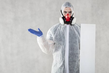 virologist in protective clothing holds advertising space in his handsの写真素材