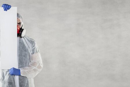 virologist in protective clothing holds advertising space in his handsの写真素材
