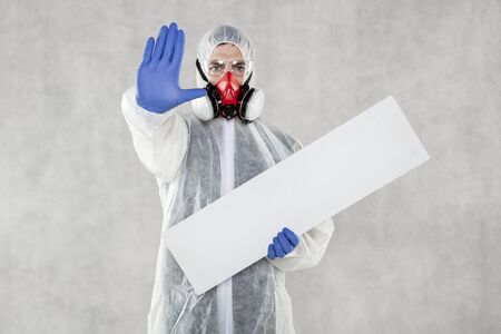 virologist in protective clothing holds advertising space in his handsの写真素材