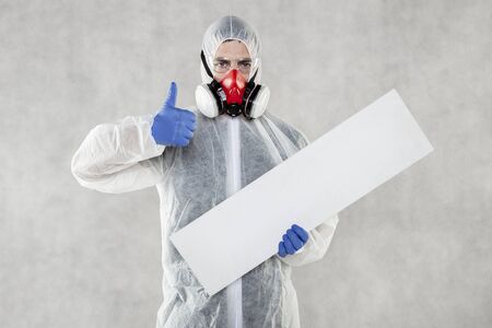 virologist in protective clothing holds advertising space in his handsの写真素材