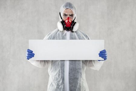 virologist in protective clothing holds advertising space in his handsの写真素材