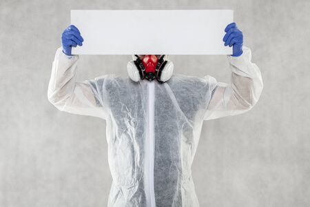 virologist in protective clothing holds advertising space in his handsの写真素材