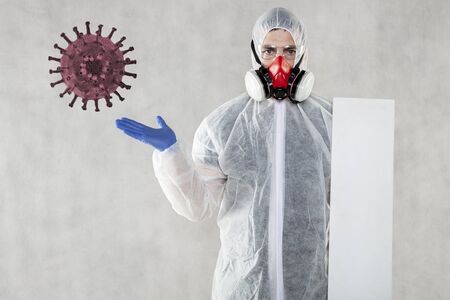virologist in protective clothing holds advertising space in his handsの写真素材